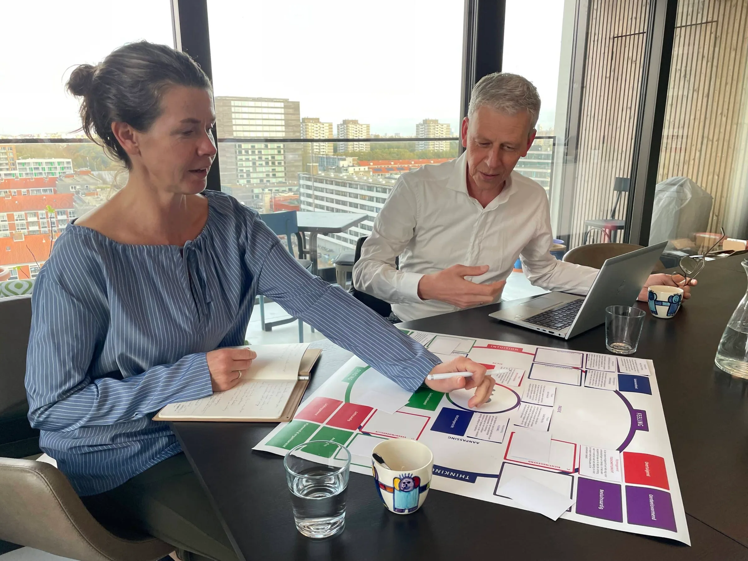 Peter Verheij in gesprek aan tafel tijdens een coachingsessie
